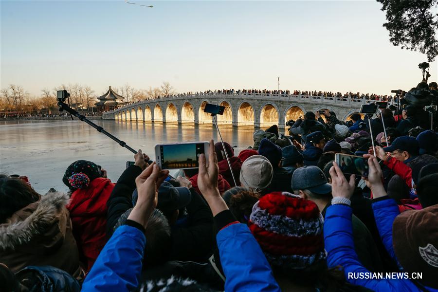 Золотой солнечный свет в 17 арках моста в парке Ихэюань